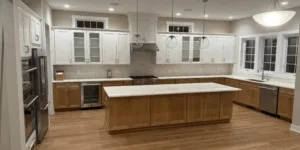 Spacious kitchen interior featuring custom wood kitchen cabinetry in oak and white finishes with a large central island.