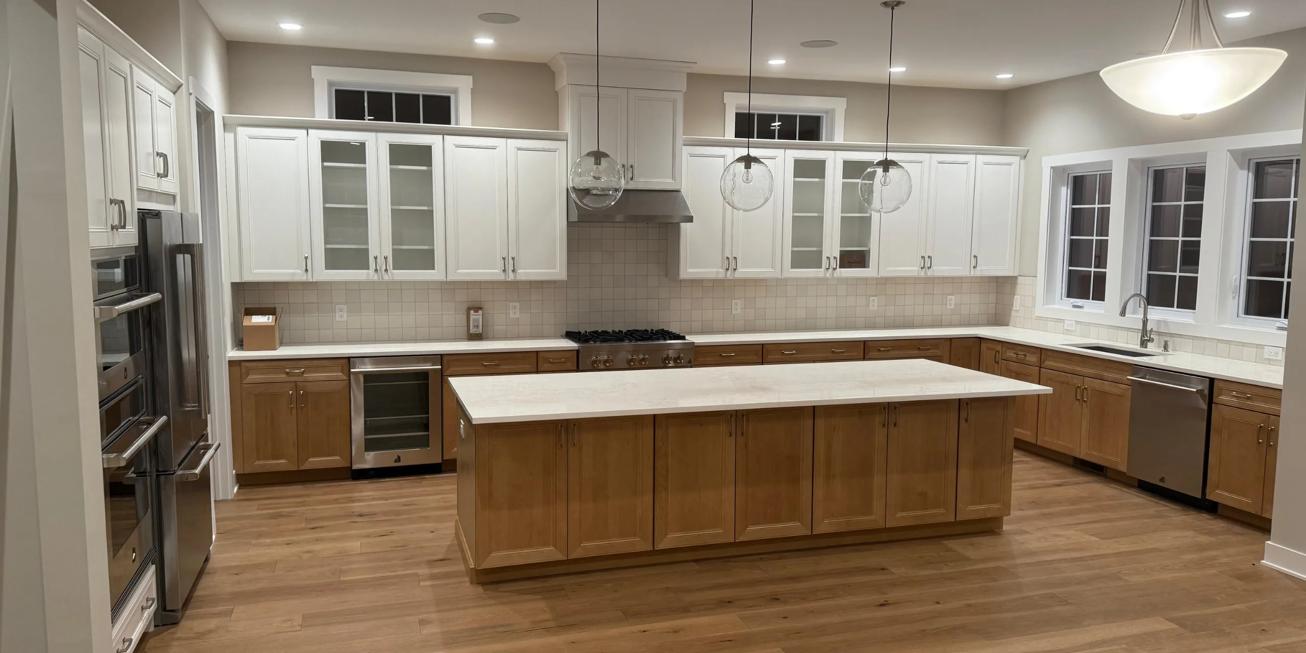 Spacious kitchen interior featuring custom wood kitchen cabinetry in oak and white finishes with a large central island.