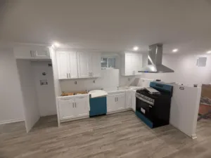 A residential kitchen featuring custom built kitchen cabinets in a white shaker style with stainless steel appliances.