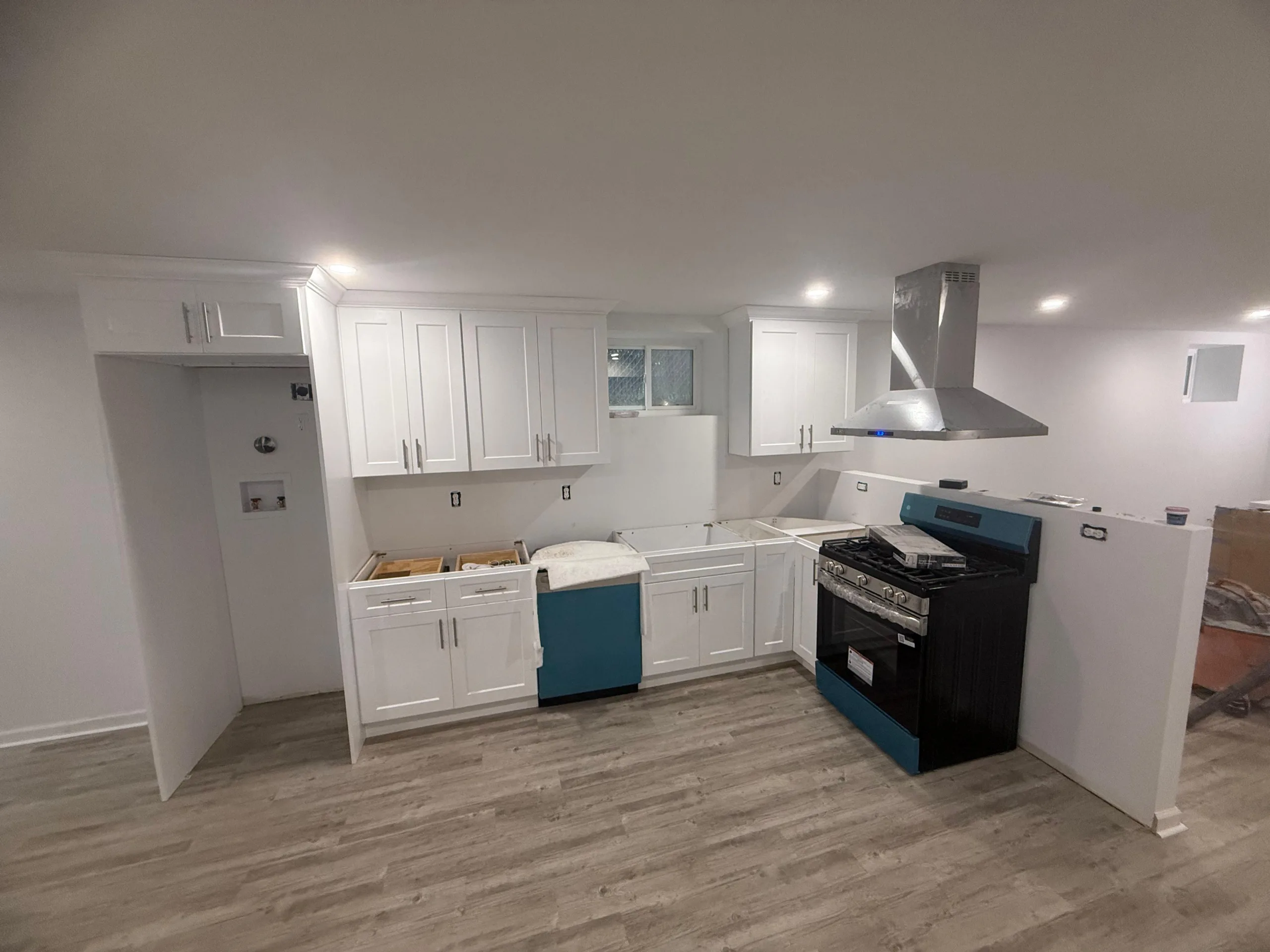 A residential kitchen featuring custom built kitchen cabinets in a white shaker style with stainless steel appliances.